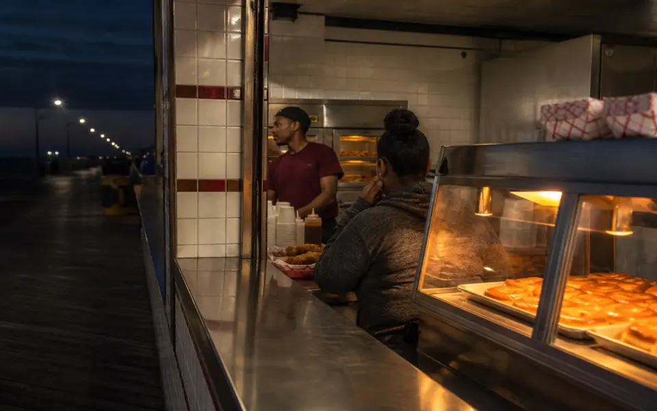 Illustration: a late-night counter serving fried chicken and glazed doughnuts under warm light